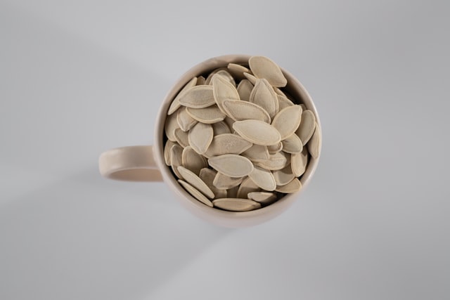 dried white pumpkin seeds in a cup