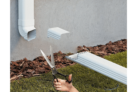 Cutting out the end of gutter extension to make a hinged downspout extension